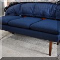 F38. Bench with navy blue upholstery and wooden legs. 18&rdquo;h x 56&rdquo;w x 22&rdquo;d 